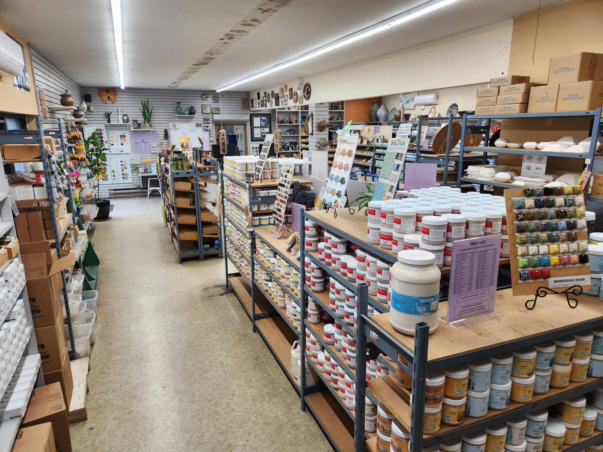 Shelves stocked with various craft supplies and painting materials in a well-organized art supply store interior.