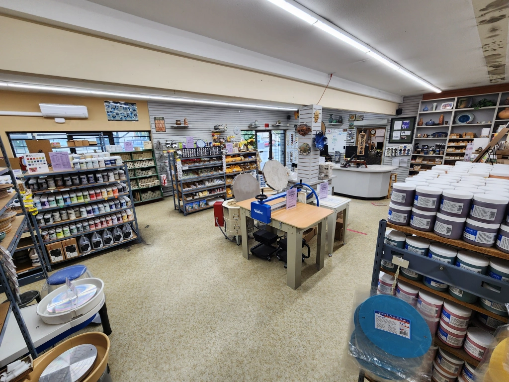 Interior view of a well-organized art supply store featuring shelves stocked with paints, brushes, and various artist materials.