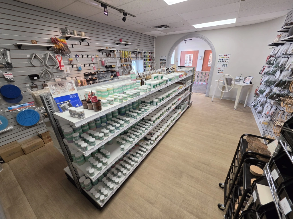 Retail store interior showing a well-organized display of small electronic accessories and devices with shelves and pegboards. Bright, clean environment with wooden flooring and white walls.