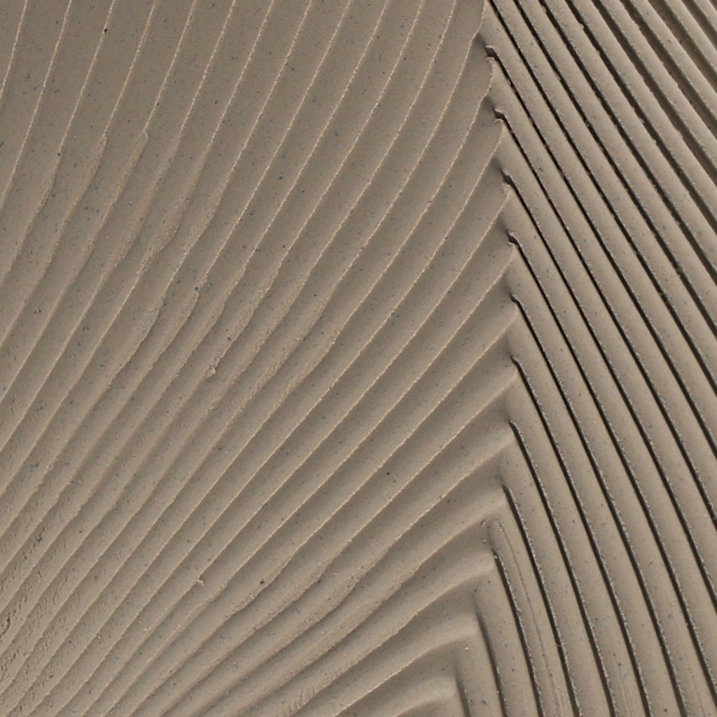 Close-up of beige corrugated cardboard with diagonal ribbed texture and shadow details.