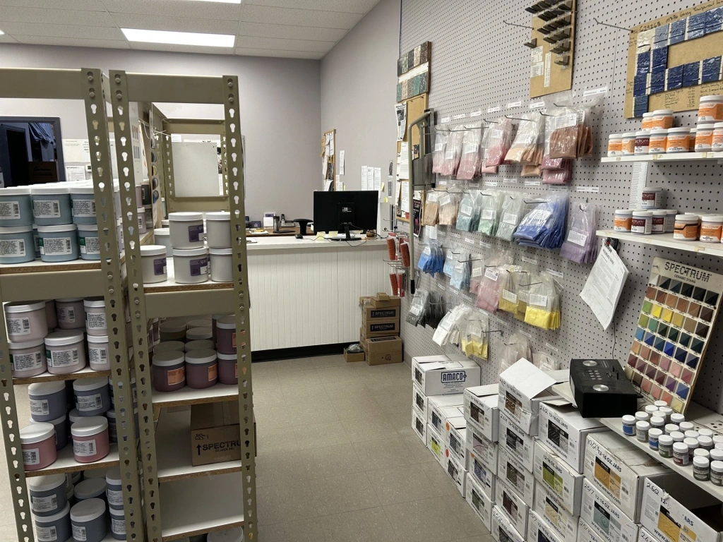 Shelves and wall display organized with various paint cans, color samples, and painting supplies inside a well-lit store.