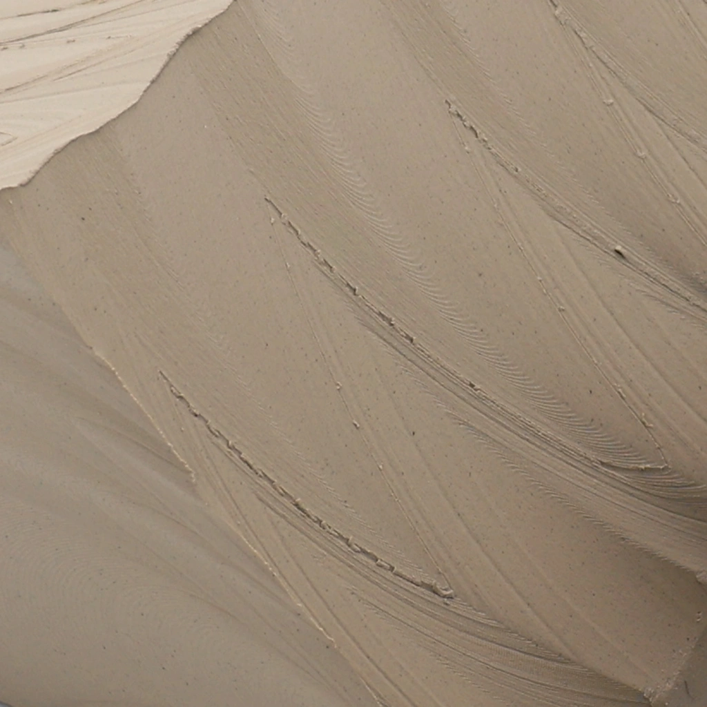 Close-up of smooth beige plaster texture on a wall with subtle brush strokes and fine cracks.