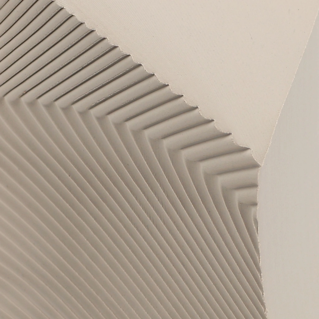 Close-up of beige acoustic wall panels with diagonal ridged pattern creating a geometric design.