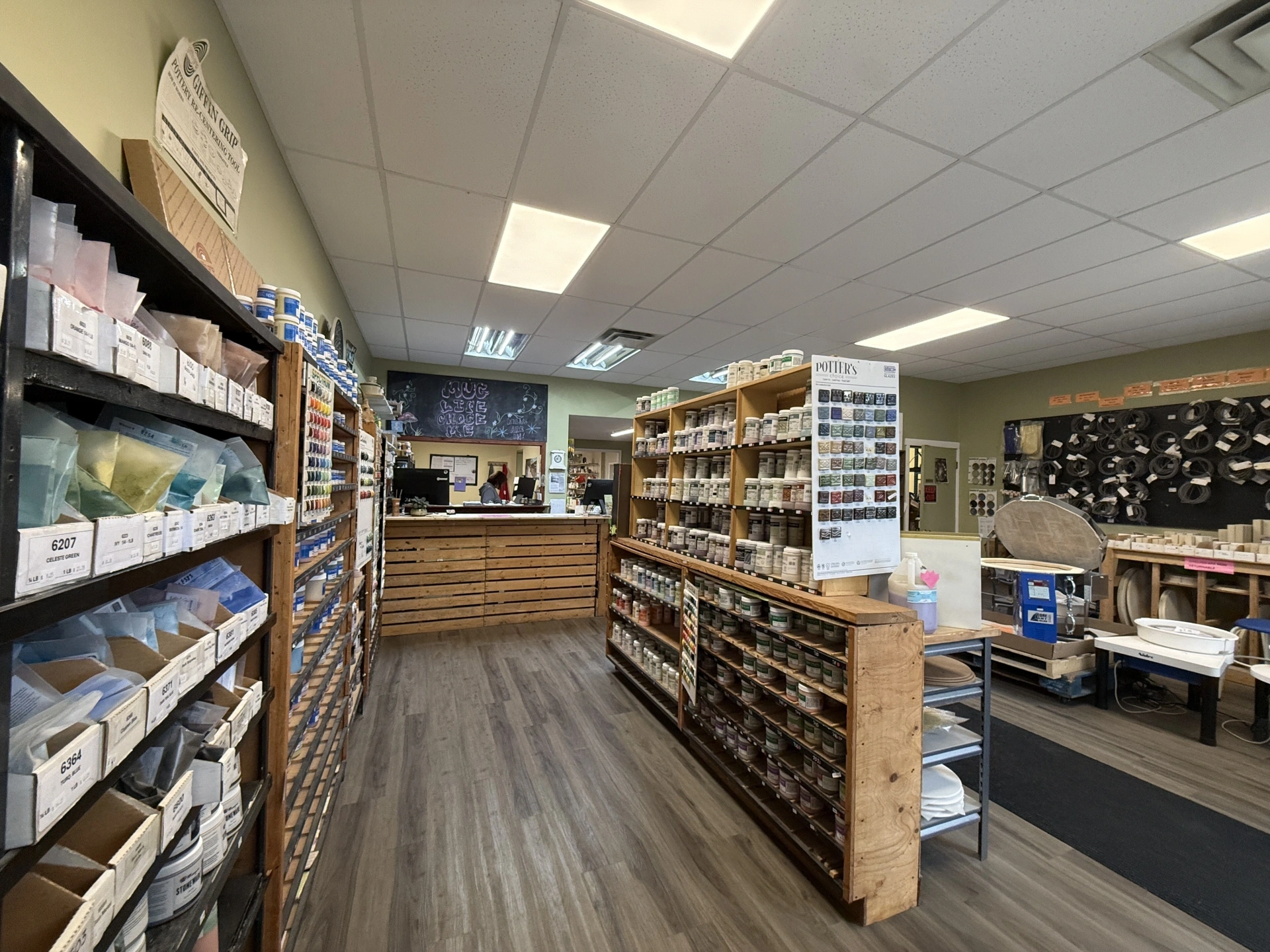 Interior view of a well-organized fabric and craft supply store with shelves stocked with various materials and a wooden counter at the back.