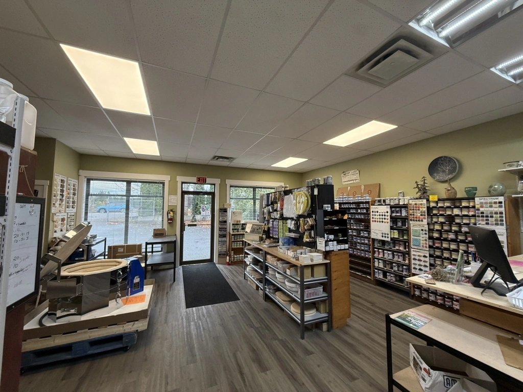 Interior view of a well-organized pharmacy with shelves stocked with medications and a customer service counter near the entrance.